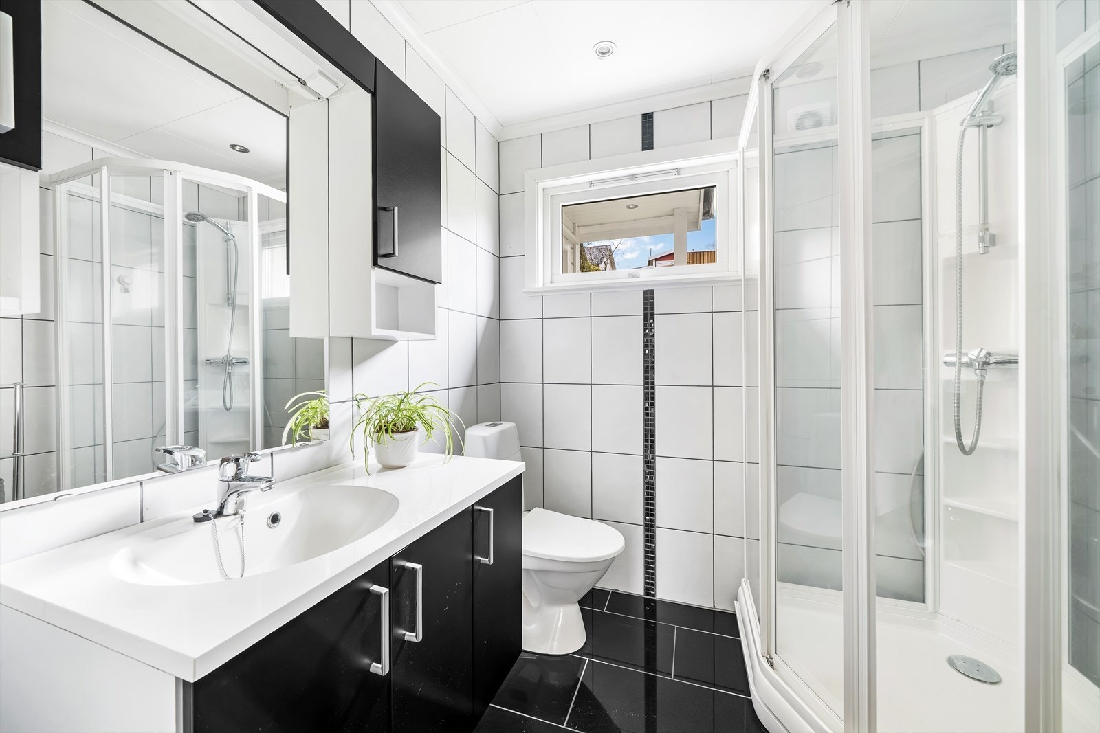 Moderne bad med stilrene fliser, dusjkabinett og baderomsinnredning. Galleribilde