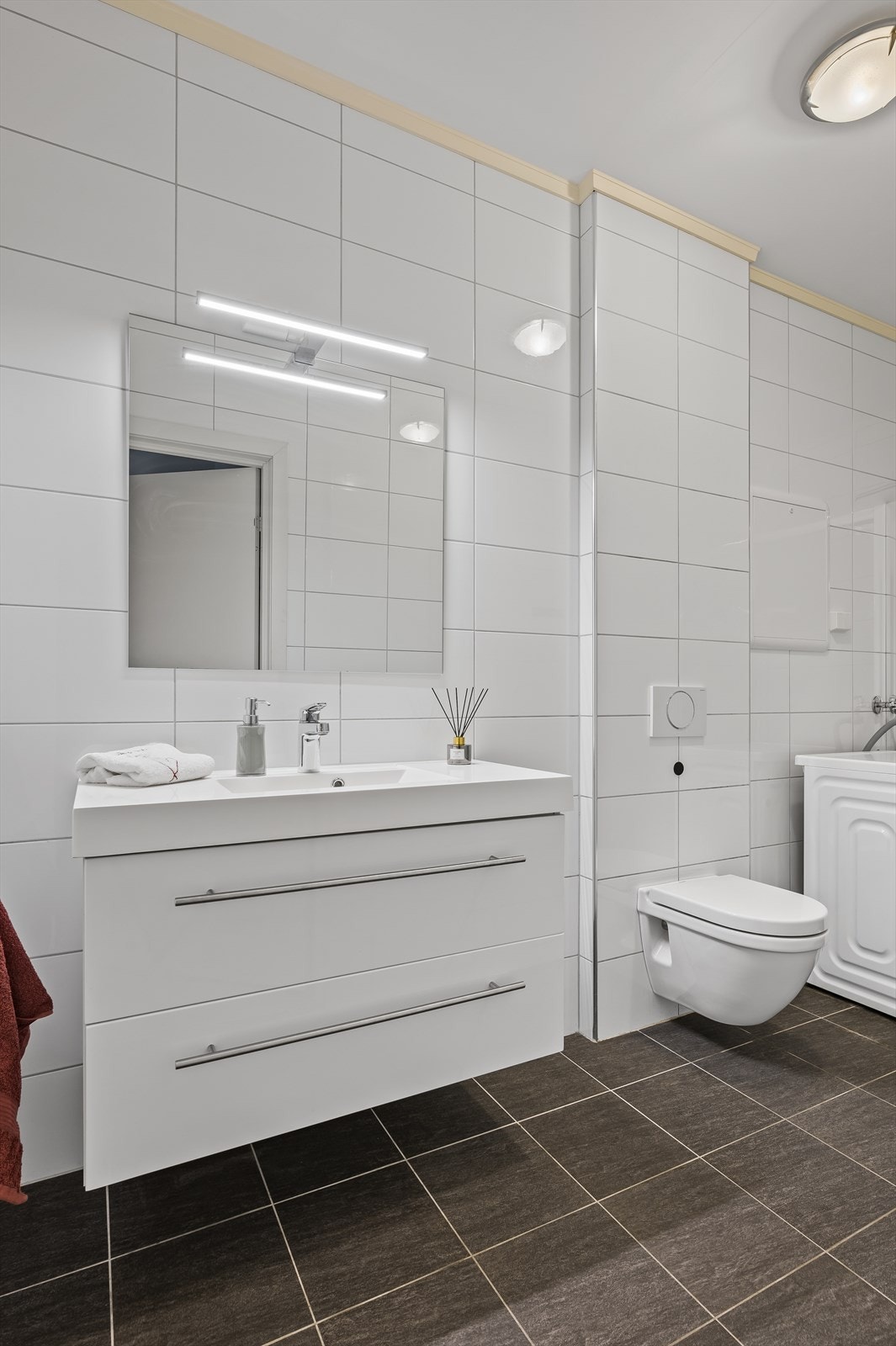 Flislagt på gulv og vegg. Vegghengt toalett, servantskap, dusjhjørne Galleribilde