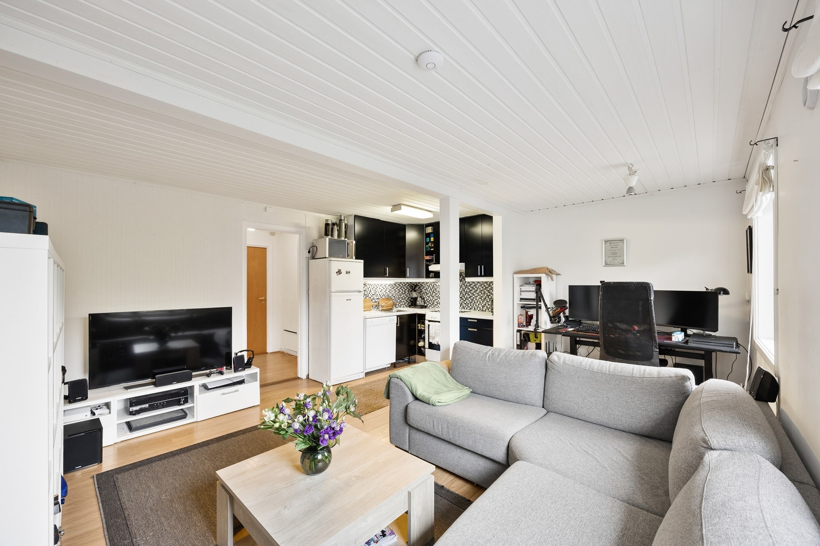 Boligens leilighet i kjelleretasje består av entré, gang, bad, rom benyttet som soverom, stue/kjøkken og innvendig bod. Galleribilde