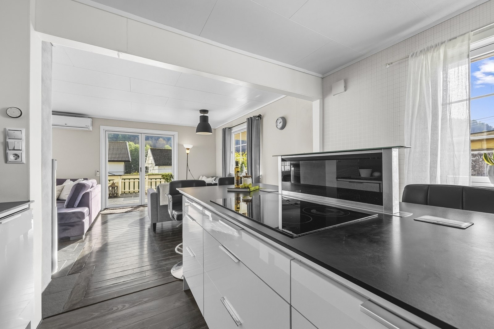 Egen kjøkkenøy med spiseplasser, platetopp og integrert ventilator. Galleribilde