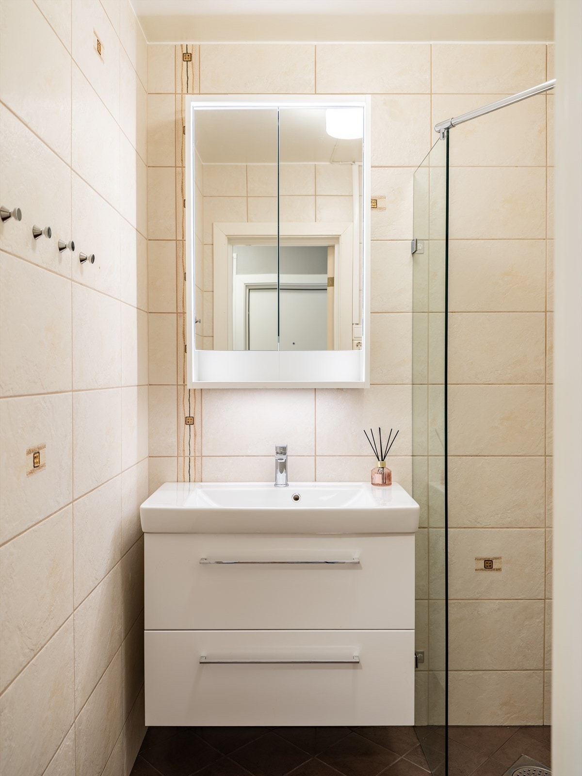 Badet er utstyrt med dusjhjørne, opplegg for vaskemaskin, servant og servantskap. Galleribilde