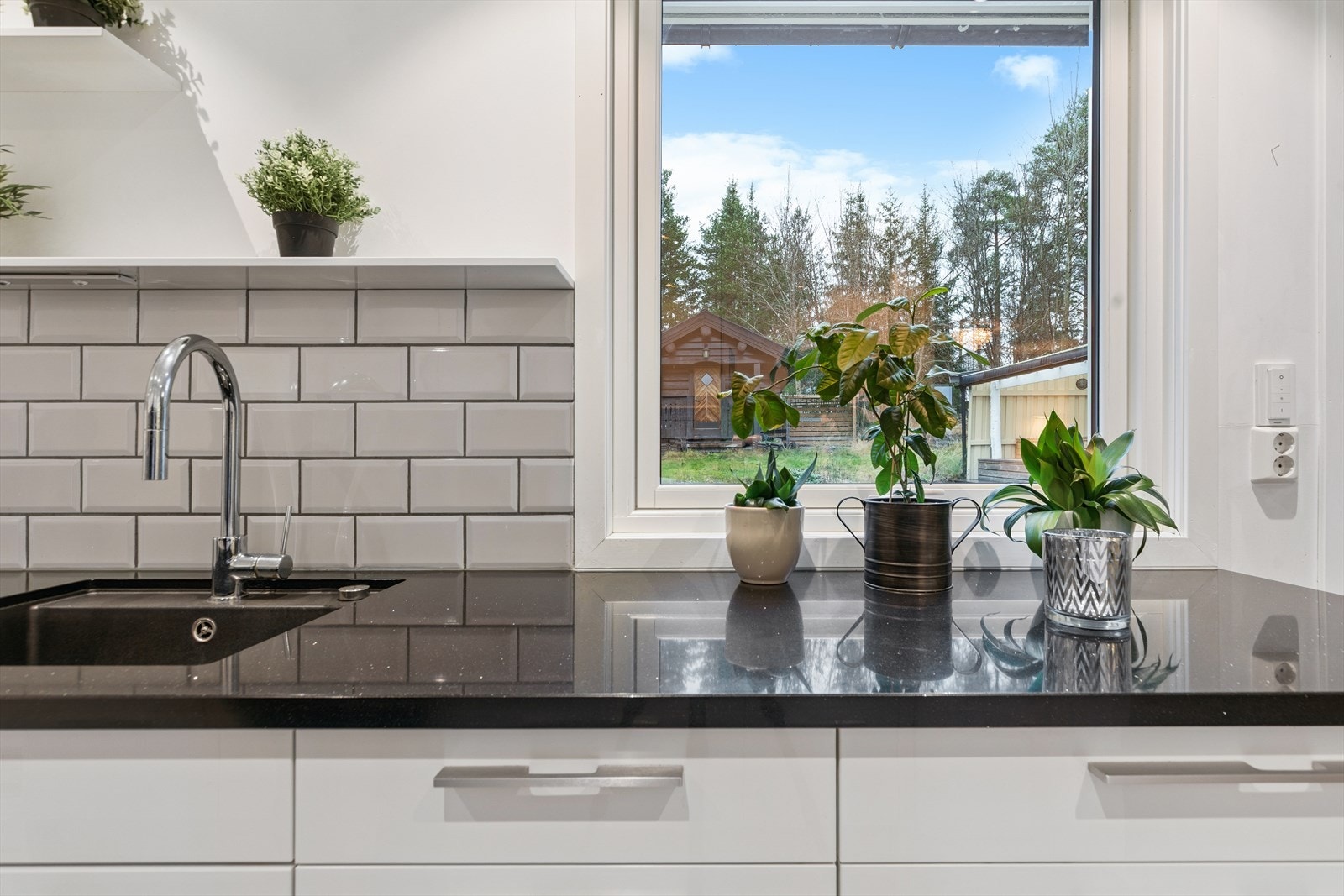 Her har man lekker benkeplate i granitt, og fliser mellom benk og overskap. Galleribilde