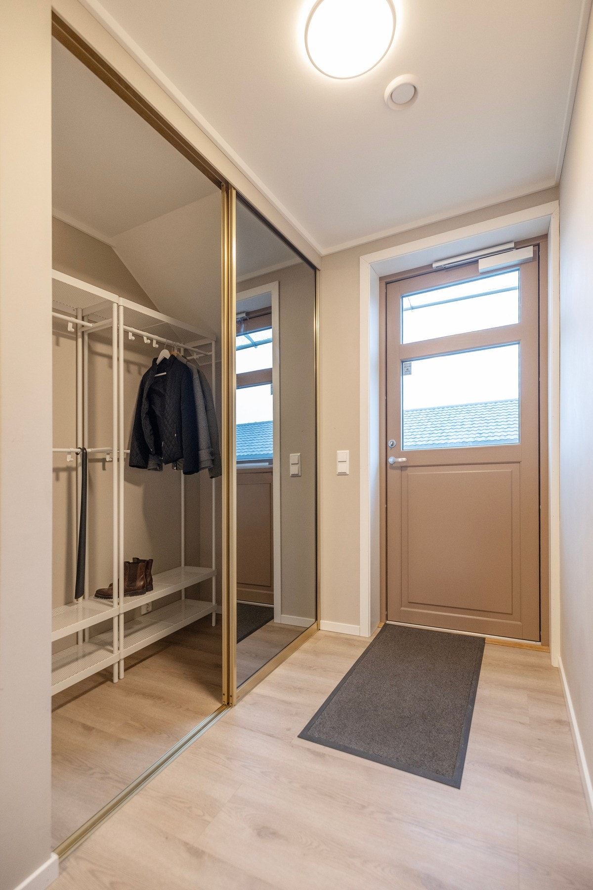 Gang/entrè med romslig og praktisk speil skyvedørsgarderobe Galleribilde