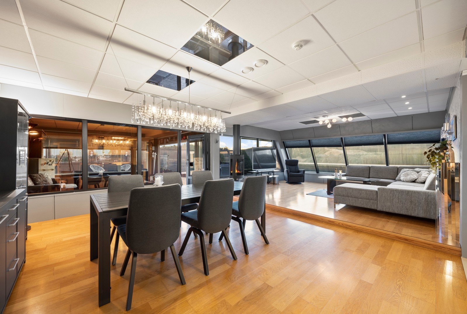 Den åpne stue- og kjøkkenløsningen gir en sosial og romslig følelse, med god plass til både spisebord og sofagruppe Galleribilde