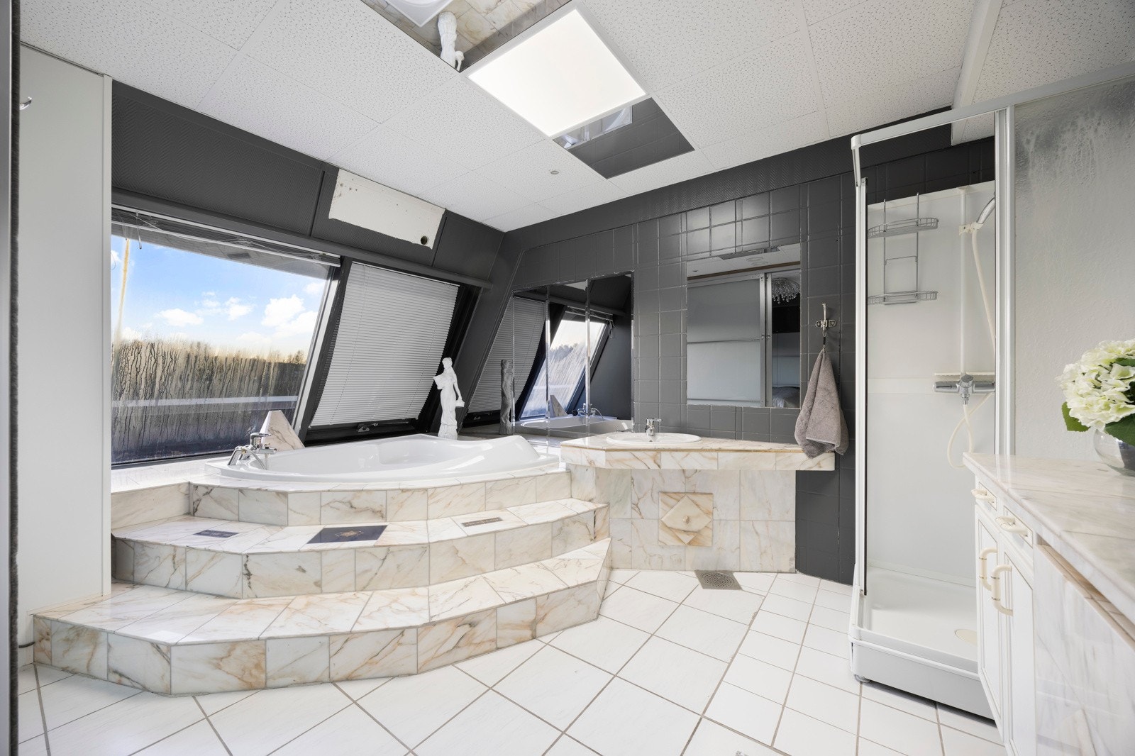 Særeget og delikat bad med plassbygget innredning av marmorflis Galleribilde