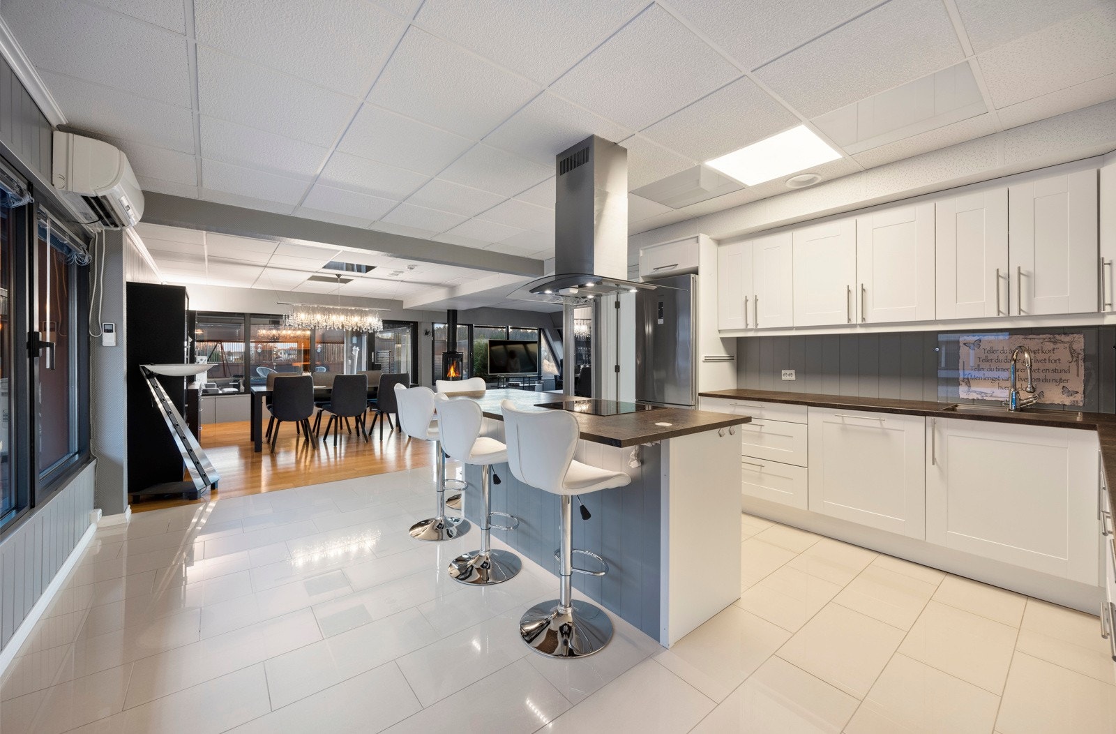 God plass til stilige barstoler ved kjøkkenøy som gjør rommet til et sosialt samlepunkt Galleribilde