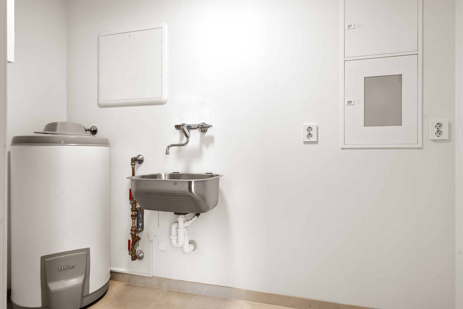 Praktisk vaskerom med utslagsvask og opplegg for vaskemaskin. Galleribilde