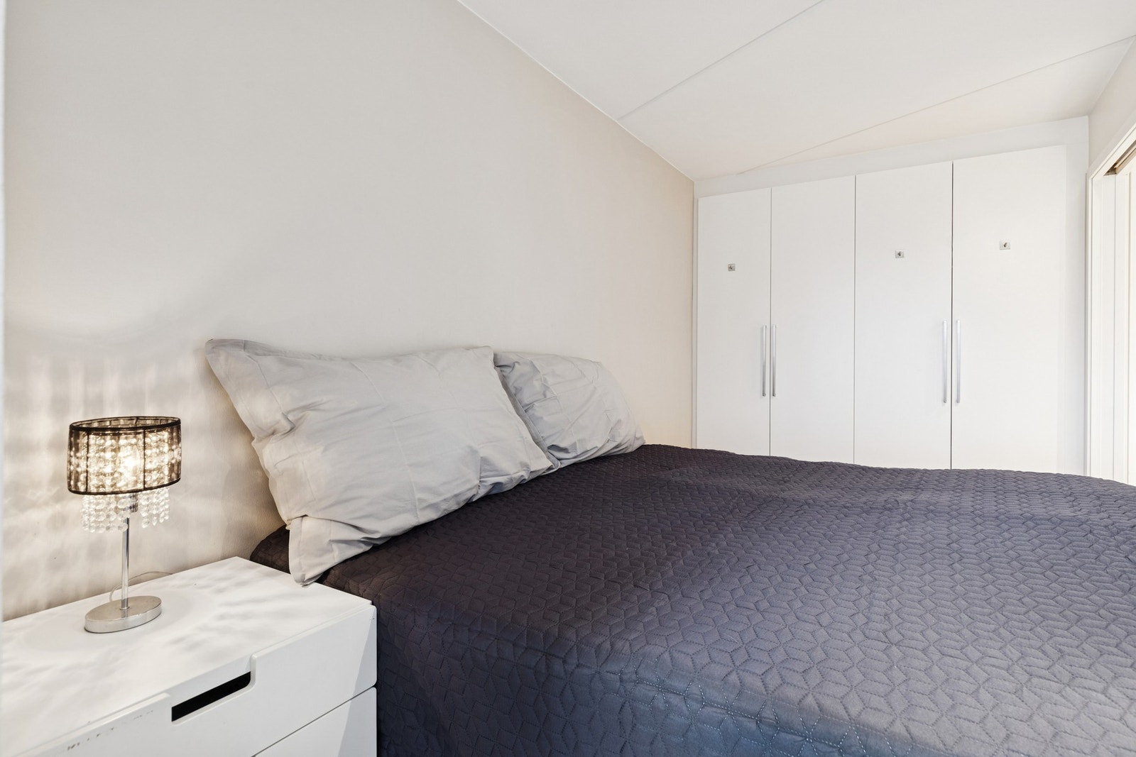 Soverommet har plass til en stor seng og nattbord på hver side. Galleribilde