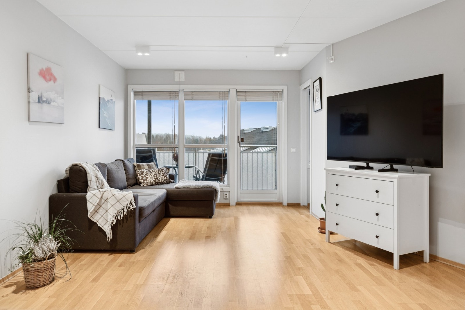 Stuen føles romslig og byr på flere møbleringsmuligheter. De store vindusflatene bringer rikelig med naturlig lys inn i leiligheten. Galleribilde