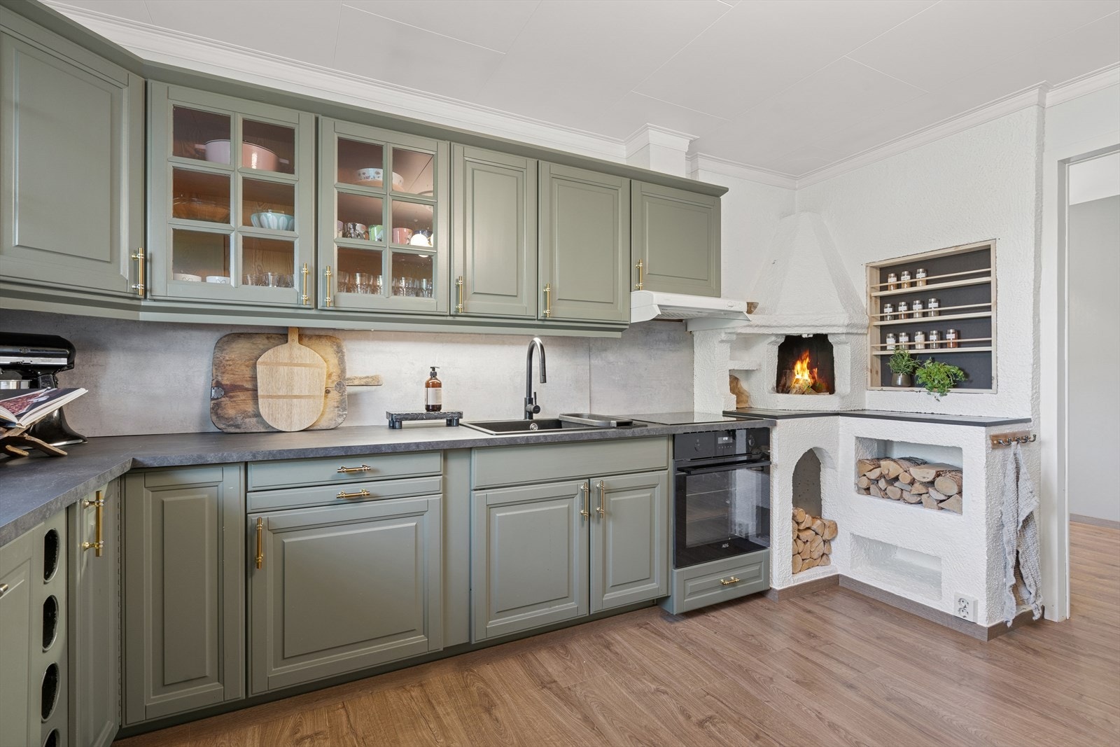 Kjøkkenet er innredet med folierte skrog med profilerte fronter og laminert benkeplate. Plater på vegg over benkeplate. Galleribilde