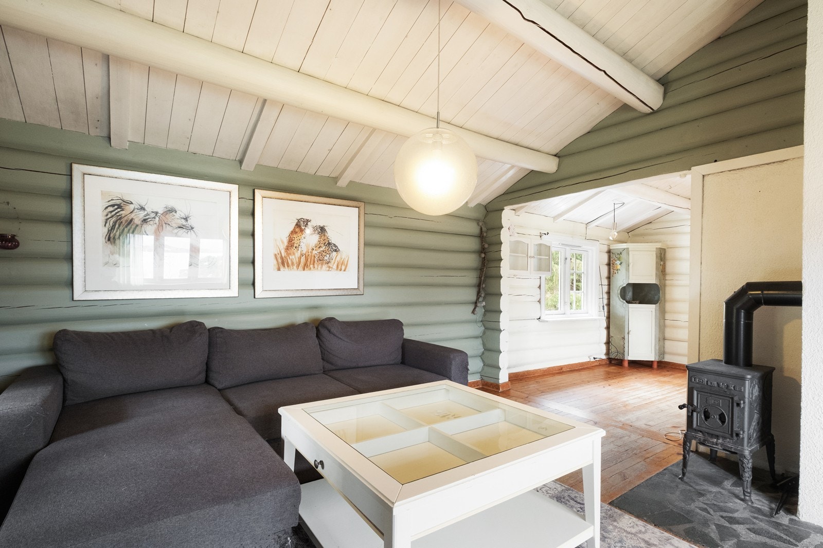 Vedovn er montert i stuen, som har tømmervegger og tak med synlige bjelker. Galleribilde