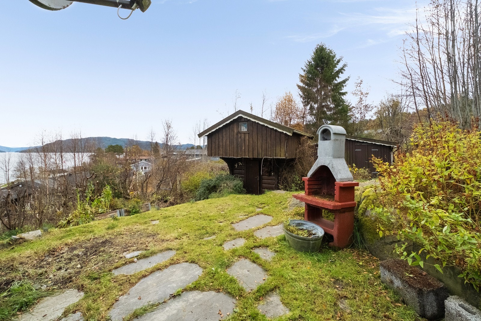 Eiendommen har stort uteområde, med grillplass og utsikt mot fjorden, ideelt for utendørs aktiviteter. Galleribilde