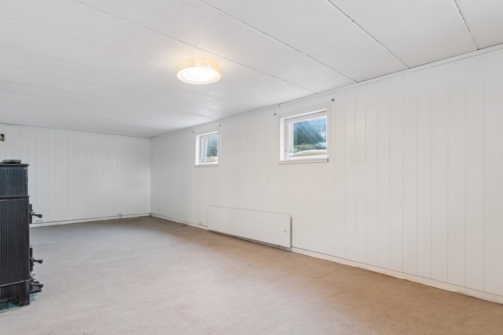 Kjellerrommet har panelkledde vegger og vinduer som slipper inn dagslys. Galleribilde