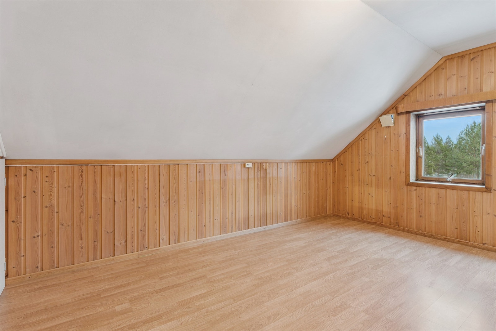 Soverom med laminat på gulv og panelkledde vegger. Galleribilde