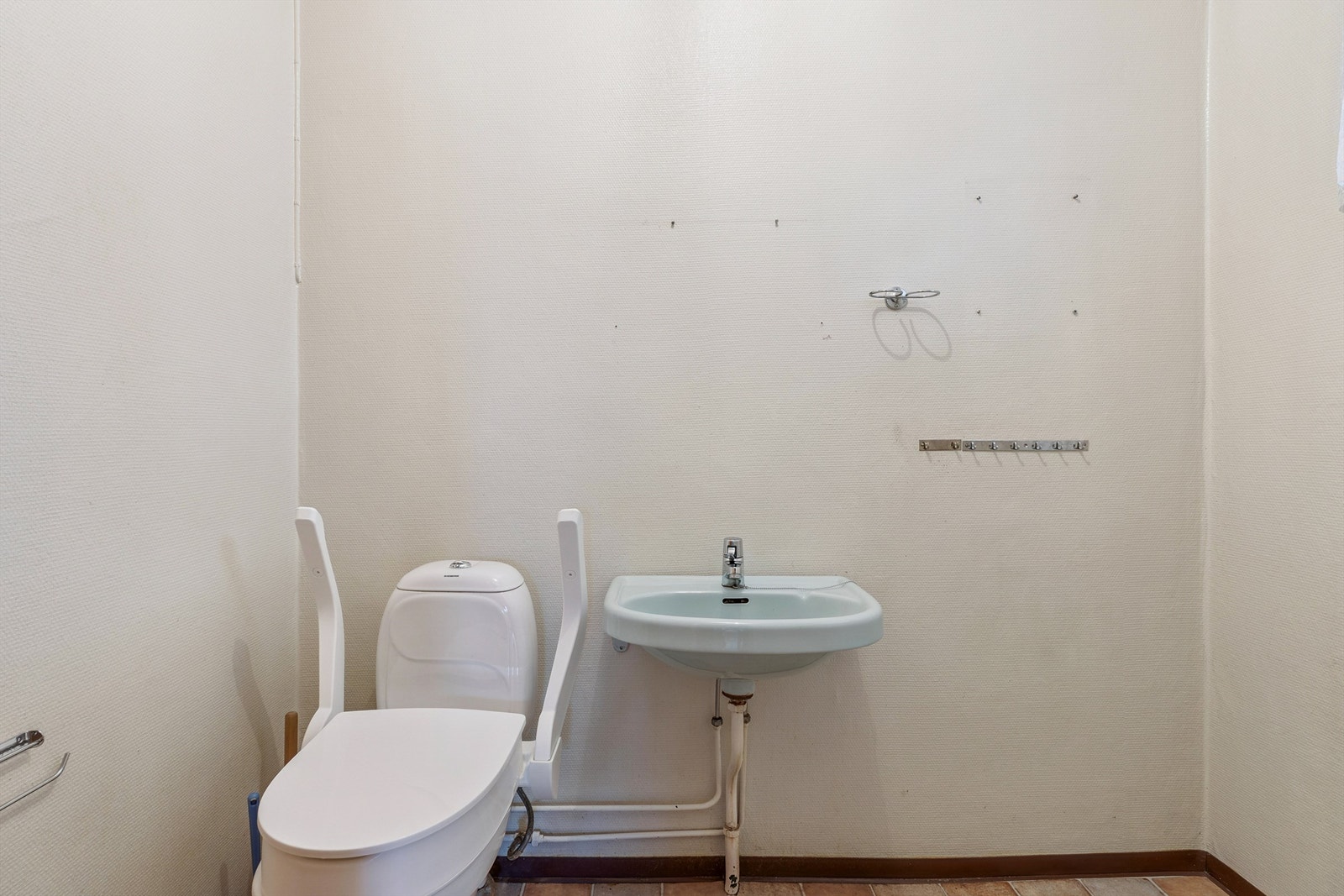 Praktisk toalettrom i første etasje, innredet med servant og toalett. Galleribilde