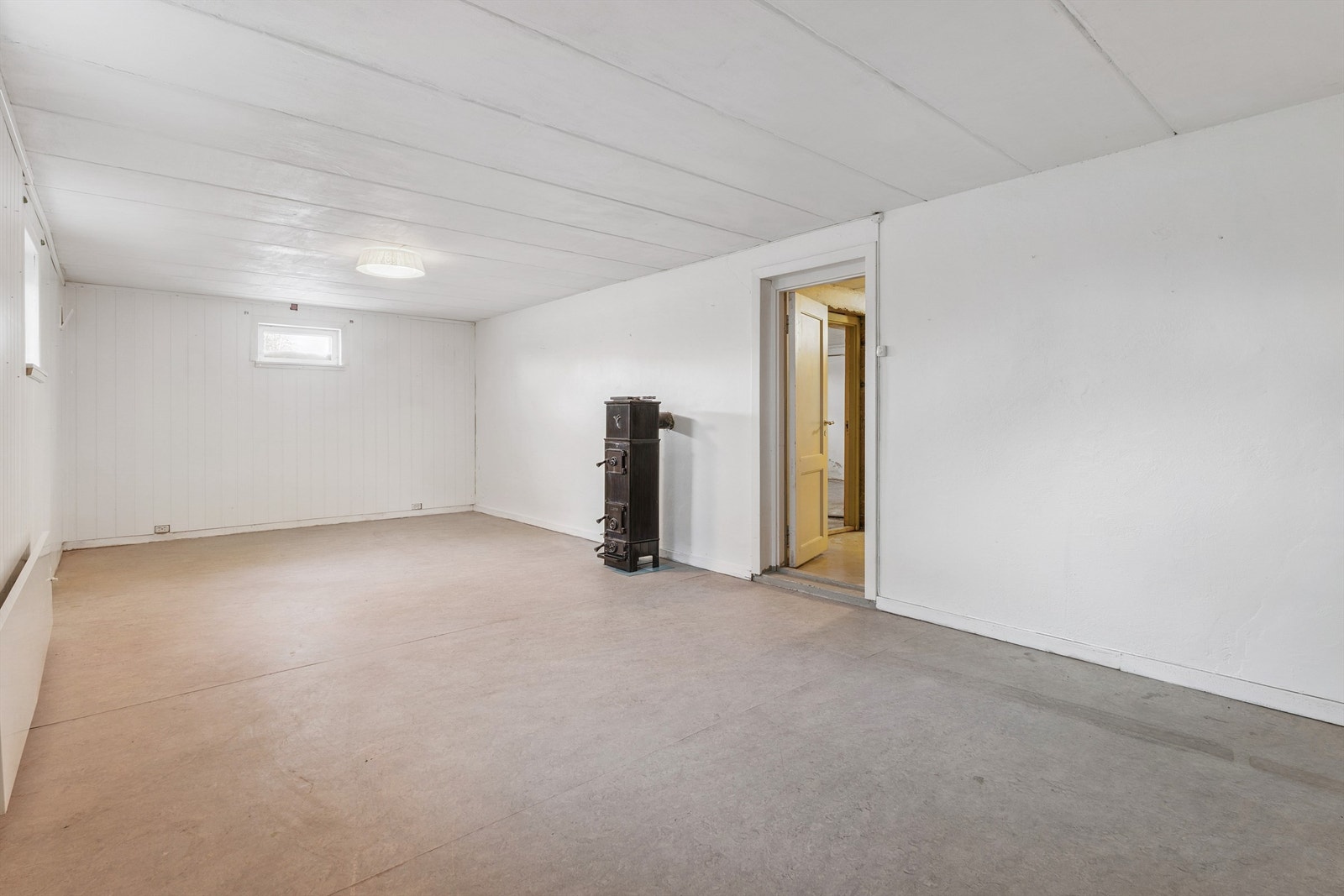 Innredet rom i kjelleren med vedovn. Rommet er ikke godkjent for varig opphold. Galleribilde
