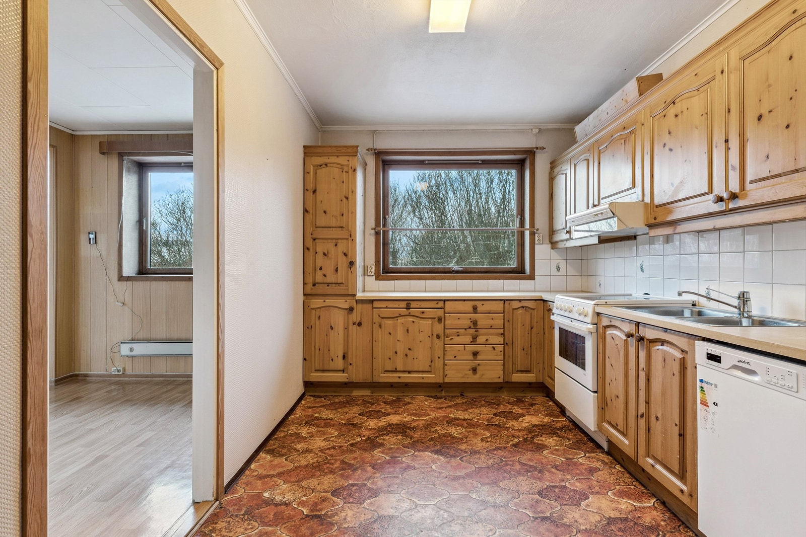 Kjøkkenet er utstyrt med åpen løsning for frittstående hvitevarer og har godt med skap- og benkeplass. Galleribilde