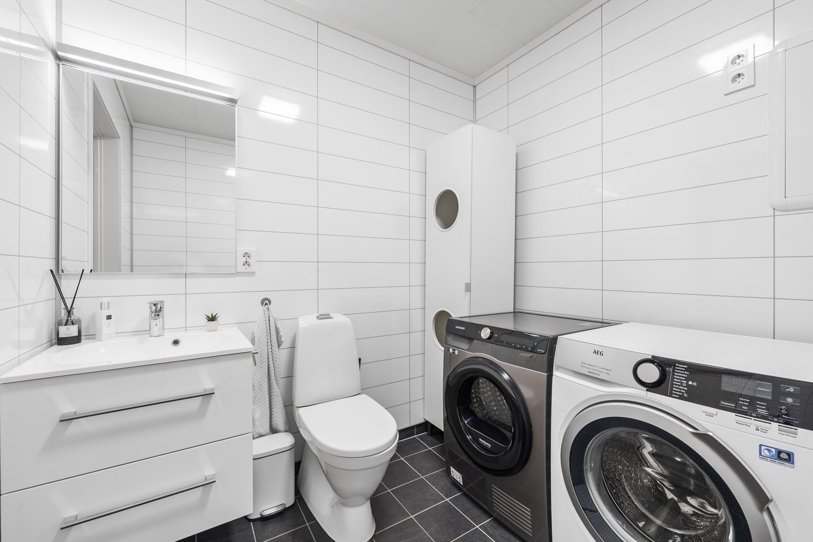 Baderom/vaskerom i 1. etasje med fliser og varme i gulv, baderomsplater på vegger Galleribilde