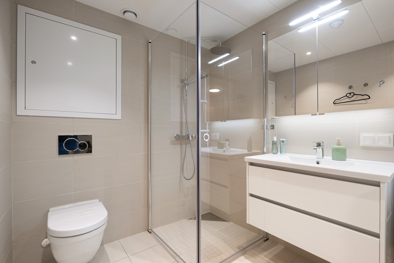 Badet er innredet med plassbesparende og innfellbare dusjvegger i glass, veggmontert WC samt elektriske varmekabler i gulv. Galleribilde