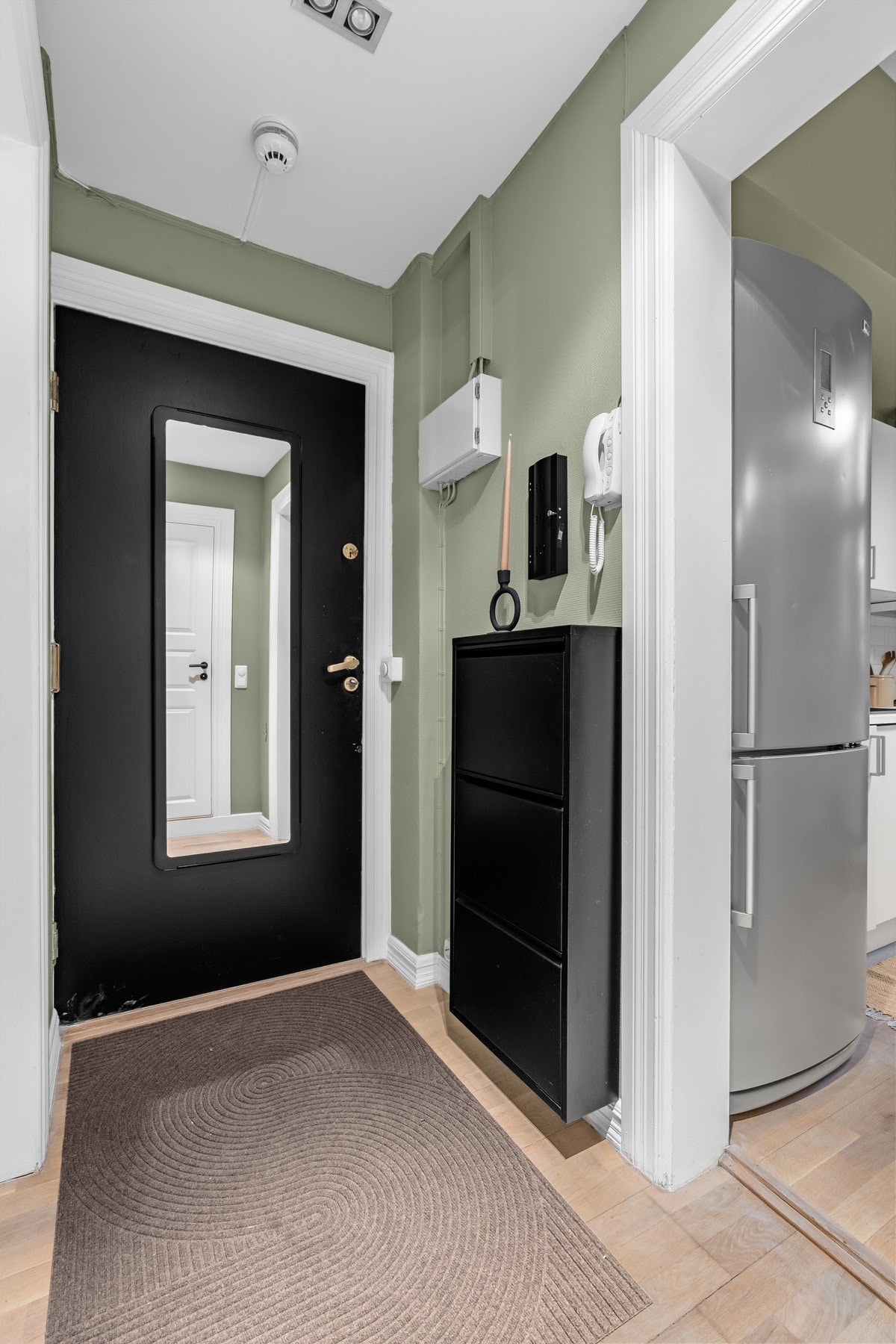 Innbydende entré med parkett på gulv, moderne fargevalg på vegger og downlights i himling. Galleribilde