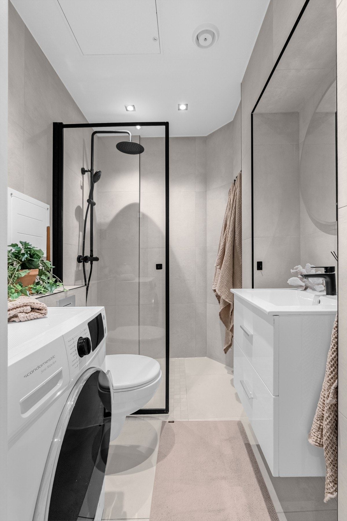 Innredningen har heldekkende servant over benkeskap med skuffer, vegghengt toalett og dusjnisje med regnfallsdusj. Galleribilde