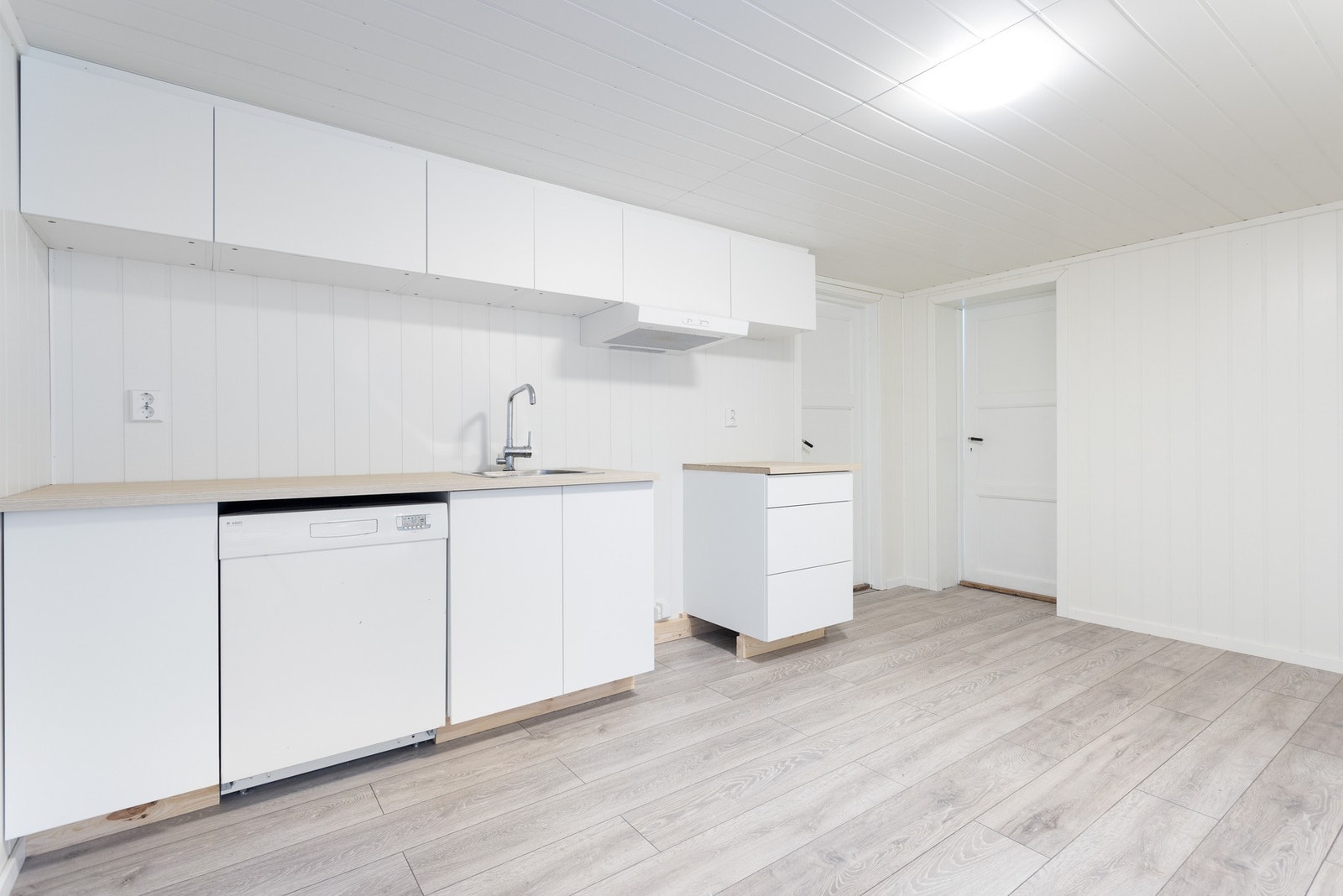 Enkel kjøkkeninnredning med vask og ventilator, ellers medfølger ingen øvrige hvitevarer. Galleribilde