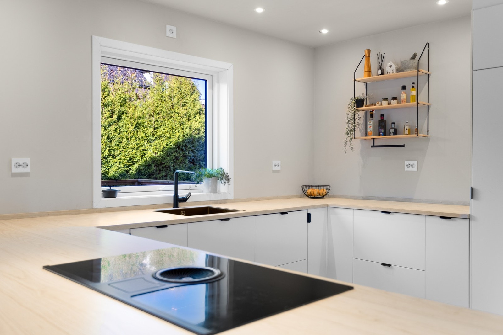 Lyst og innbydende kjøkken med integrerte hvitevarer. Galleribilde