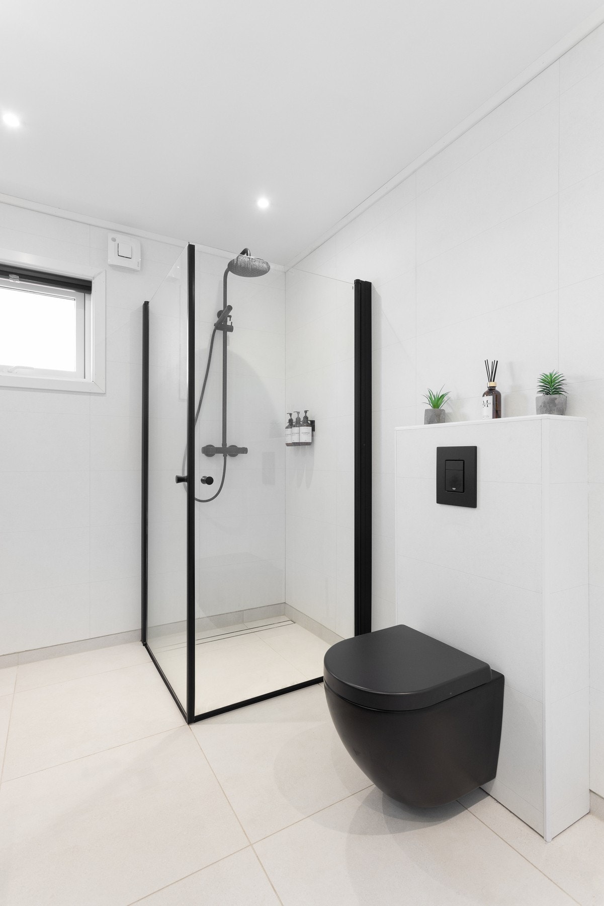 Romslig bad med dusjløsning og stilrene overflater. Galleribilde