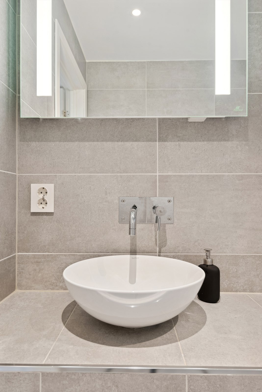 Flislagt benk med bolleservant og speil med lyspunkter Galleribilde