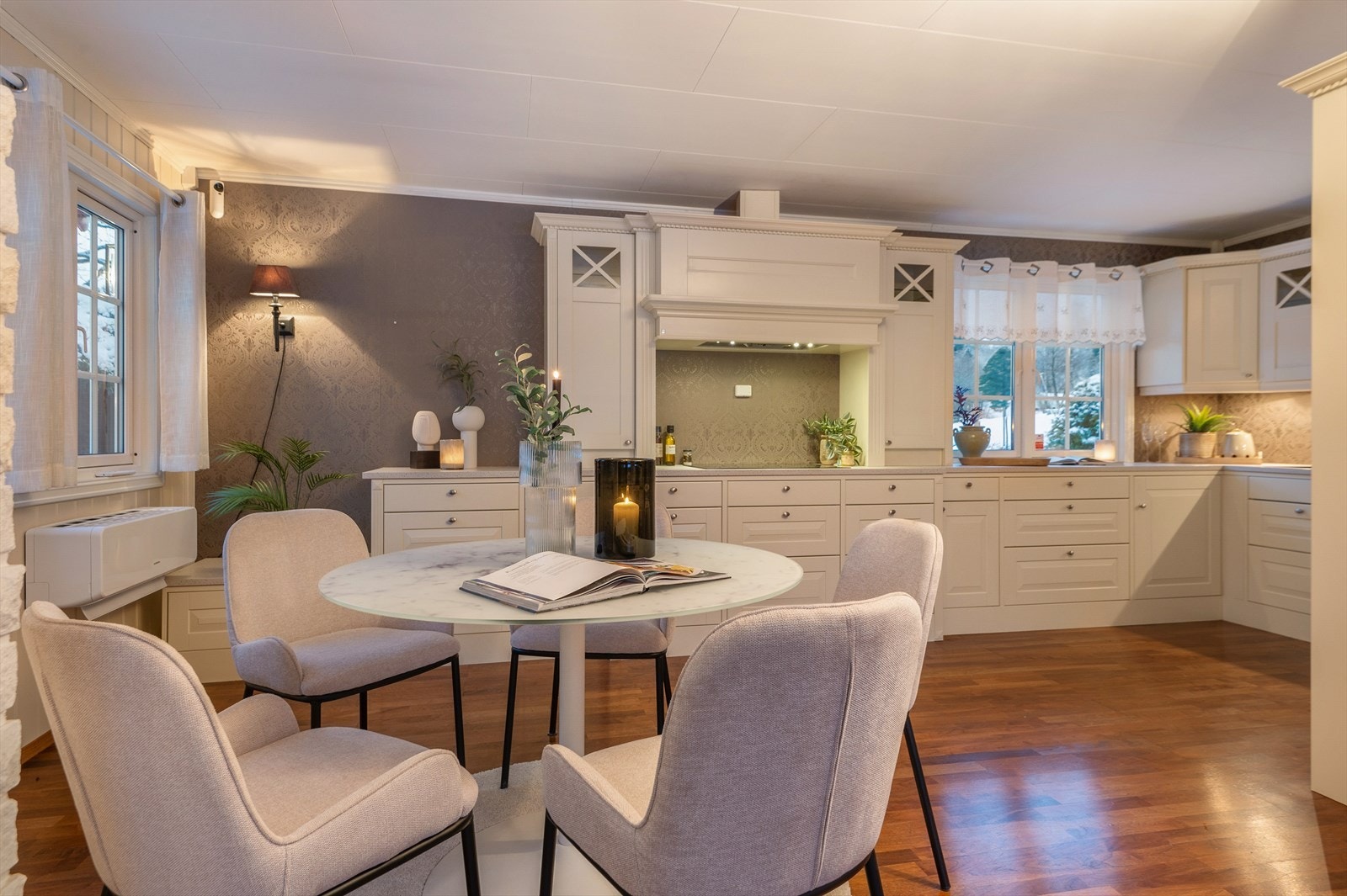 Innredningen består av hvite profilerte fronter, benkeplate i laminat, oppvaskkum med blandebatteri, integrert koketopp, stekeovn, oppvaskmaskin, kjølehjørne og fryseskap. Galleribilde