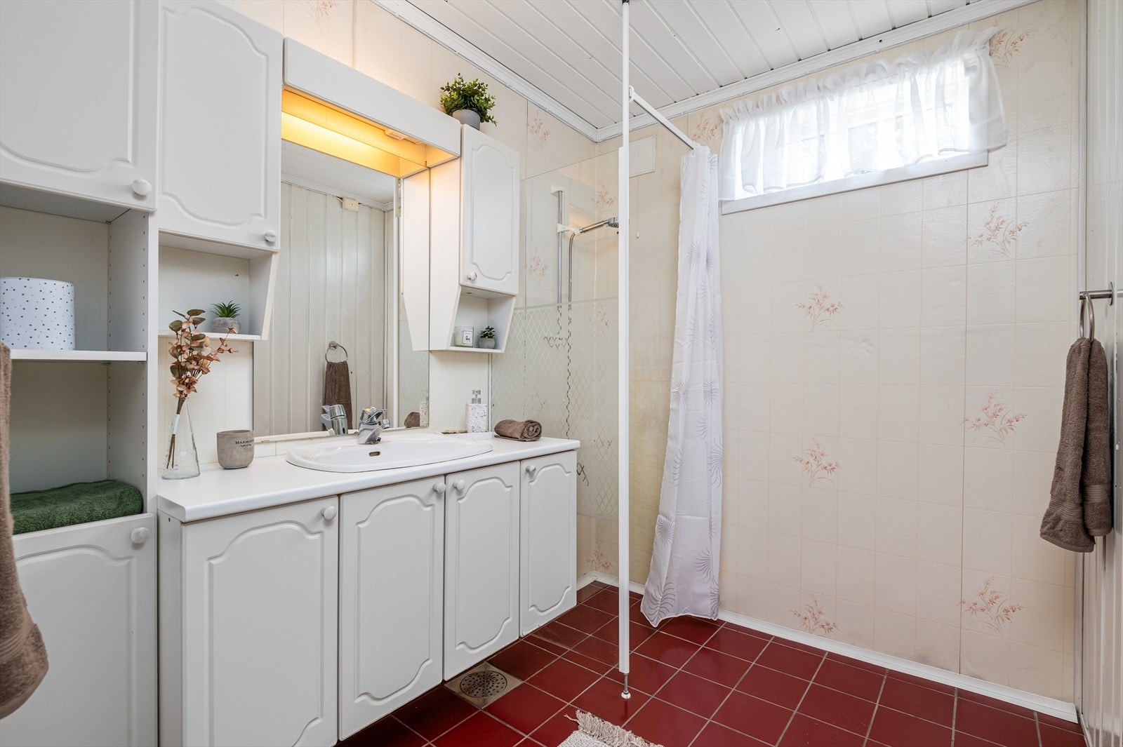 Badet måler 6 kvm og er innredet med fliser på gulv, våtromstapet på vegg og malt panel i himling. Galleribilde