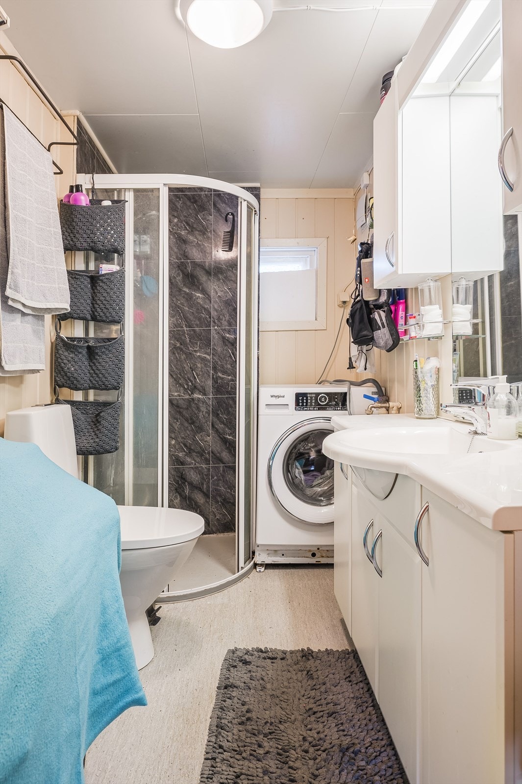 Bad med hjørnedusj, toalett, servant med skap og speil. Galleribilde