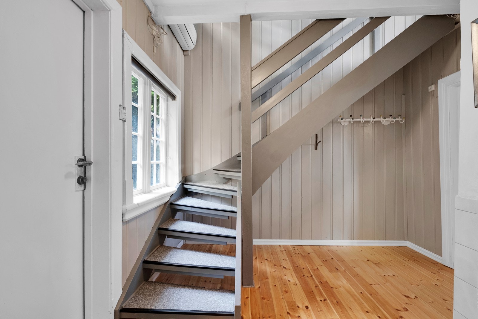 Entrè/ trapperom med godt med plass under trappa til lagring og oppheng. Varmepumpe montert i trappeløpet. Galleribilde