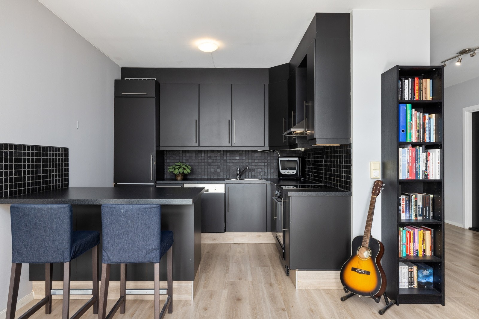 Kjøkkeninnredning med slette fronter og benkeplate i laminat med vask i rustfritt stål og 1-greps kjøkkenarmatur. Galleribilde