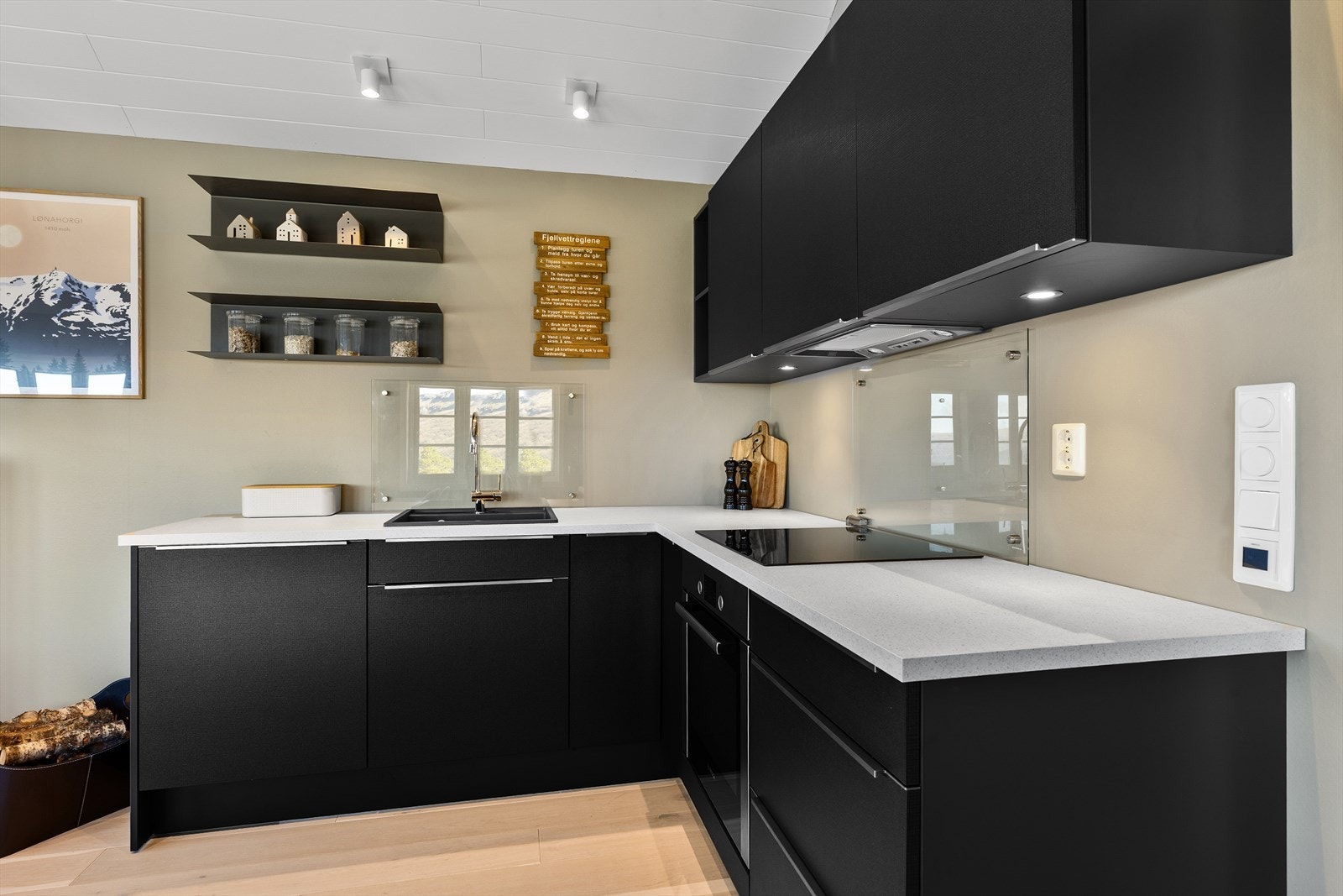 Kjøkkenet har integrerte hvitevarer som oppvaskmaskin, kjøleskap med frysedel, platetopp og stekeovn Galleribilde