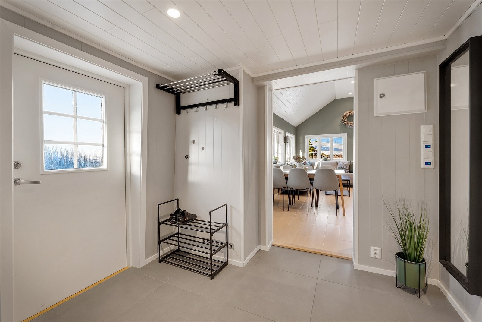 En blir ønsket velkommen inn i en flott flislagt entre med god plass til å henge fra seg yttertøy og sko Galleribilde