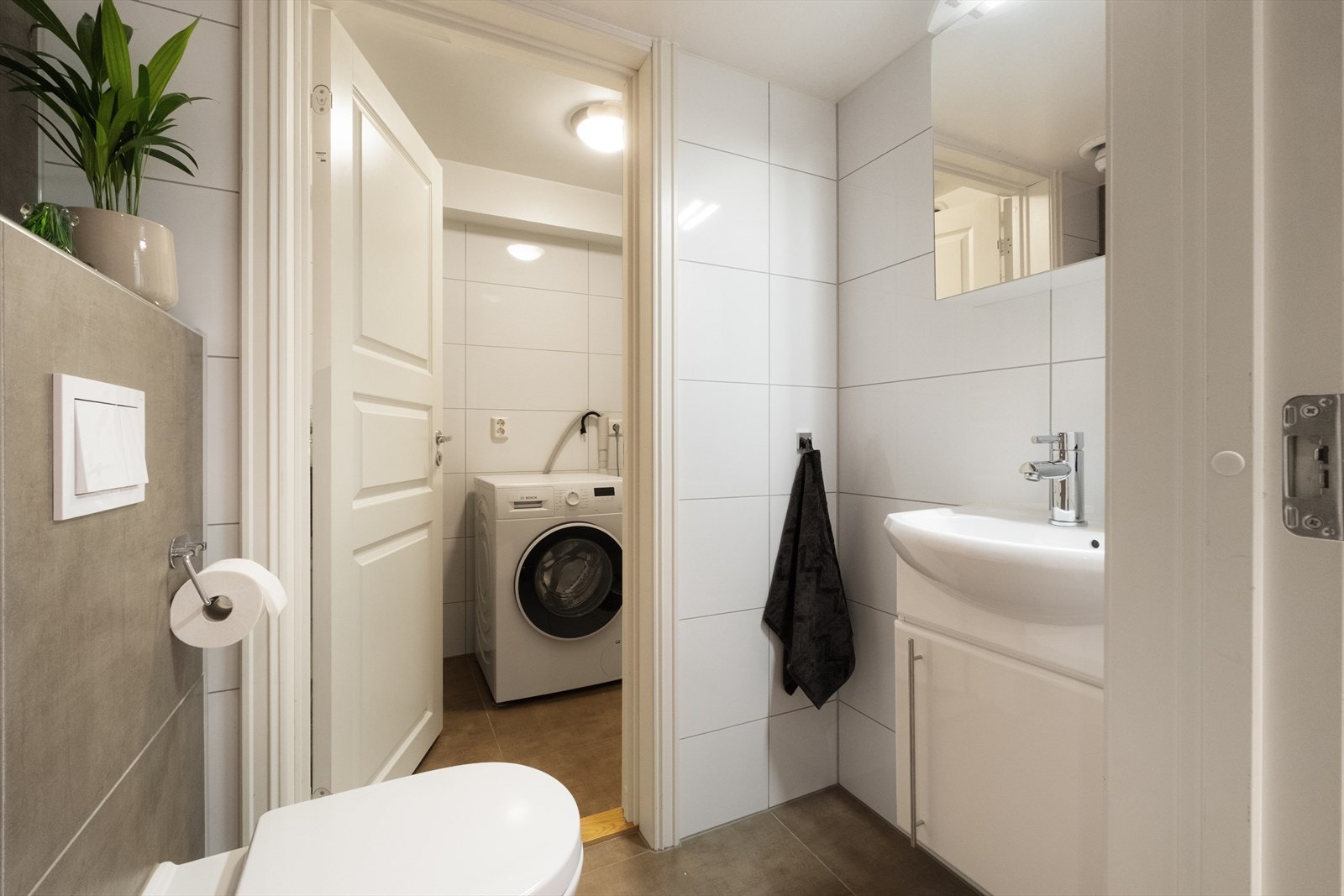 Gjestetoalett med dør direkte til vaskerommet. Galleribilde