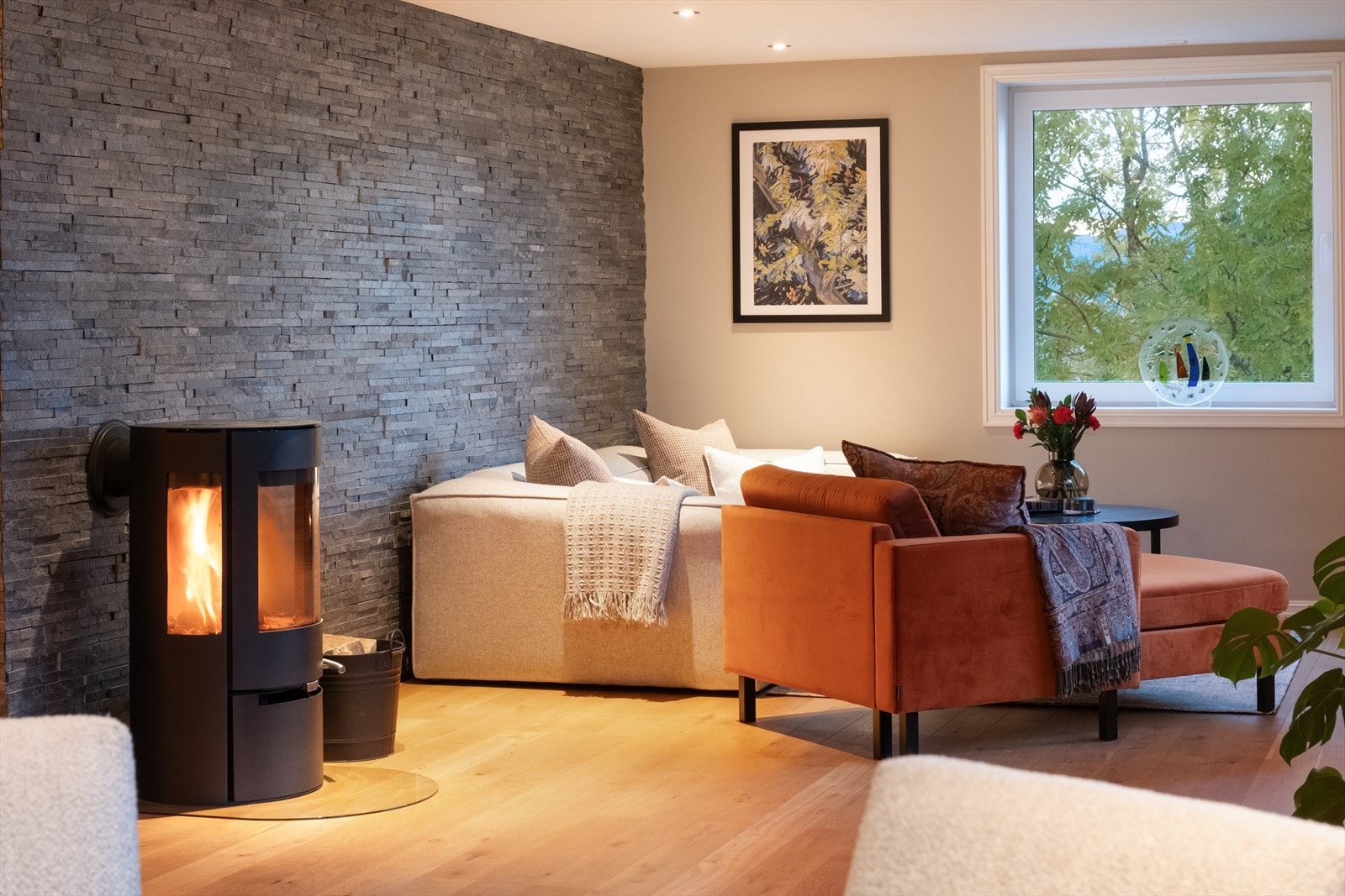 Vedovn og skiferbelagt vegg gir stuen et robust preg. Galleribilde