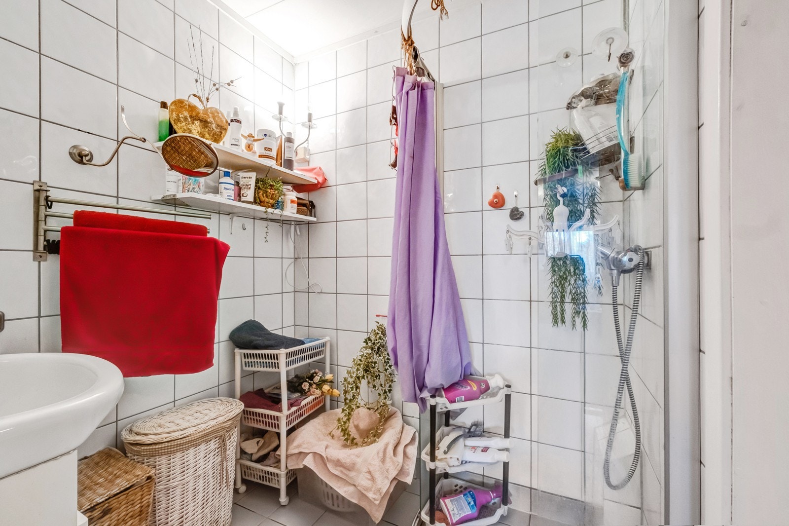 Flislagt bad utstyrt med servant med underskap og dusjnisje med glassdør. Galleribilde