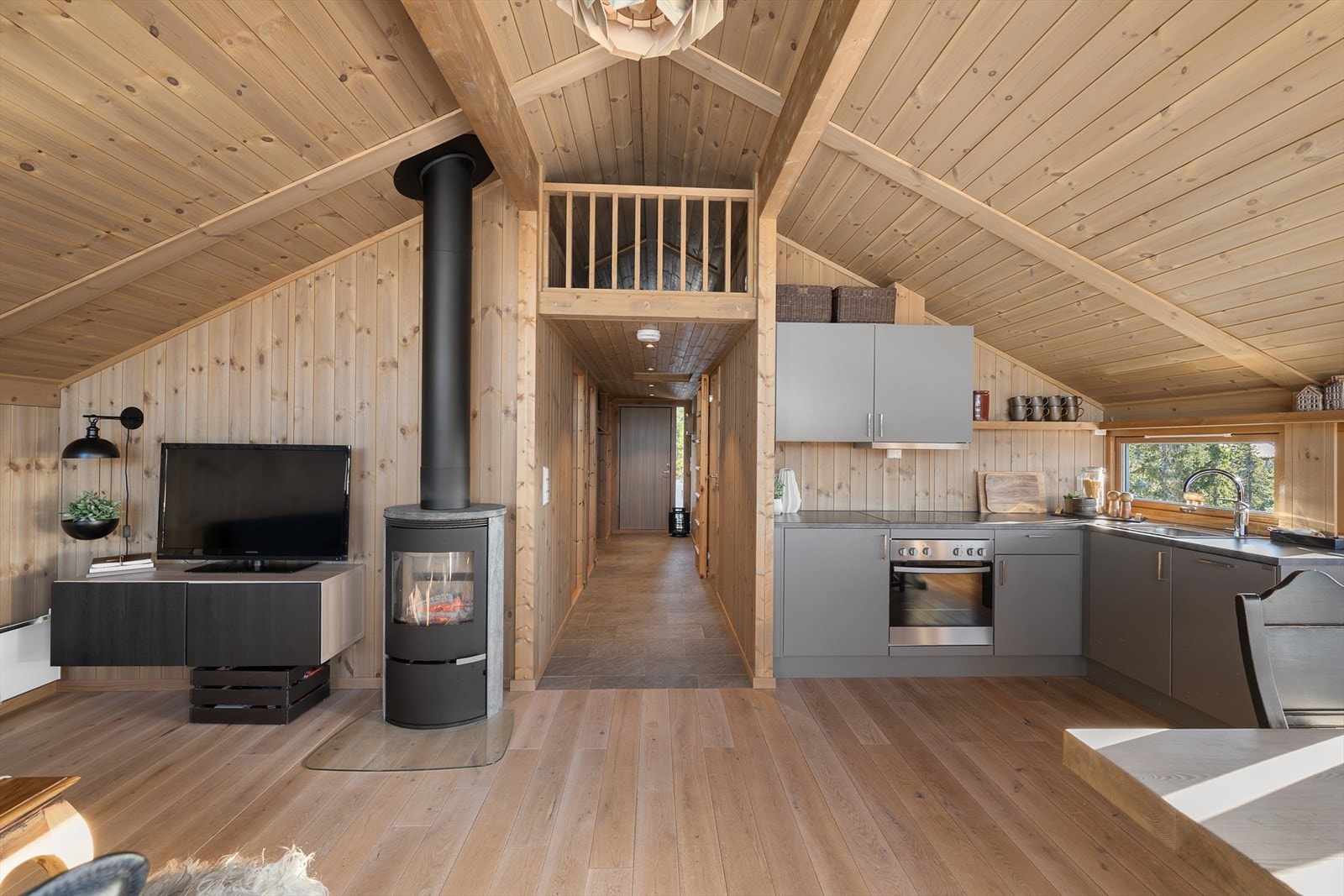 Det er er åpen og sosial løsning mellom stue og kjøkken. Galleribilde