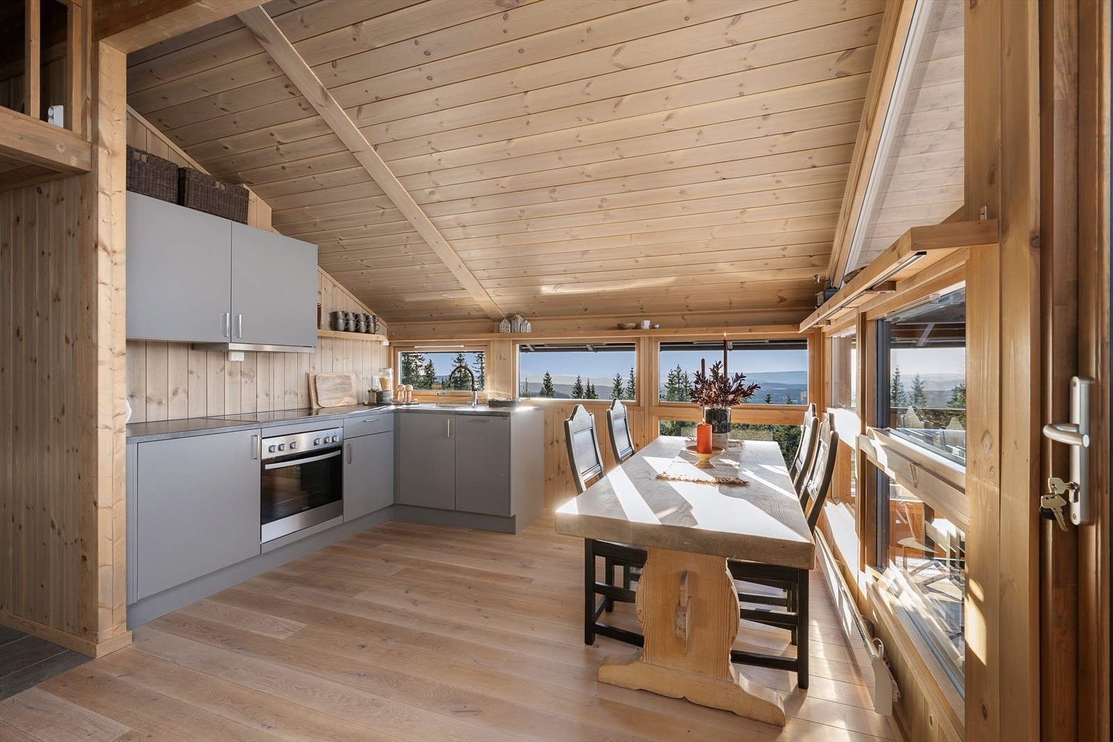 Kjøkkeninnredningen er stram og moderne med glatte fronter i en delikat og tidløs gråtone. Det er fin plass til spisebordet på kjøkkenet. Galleribilde