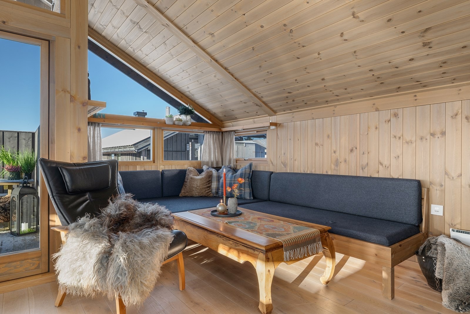 En koselig sofakrok ved vinduet. Dør ut til en delvis overbygget og hyggelig terrasse. Galleribilde