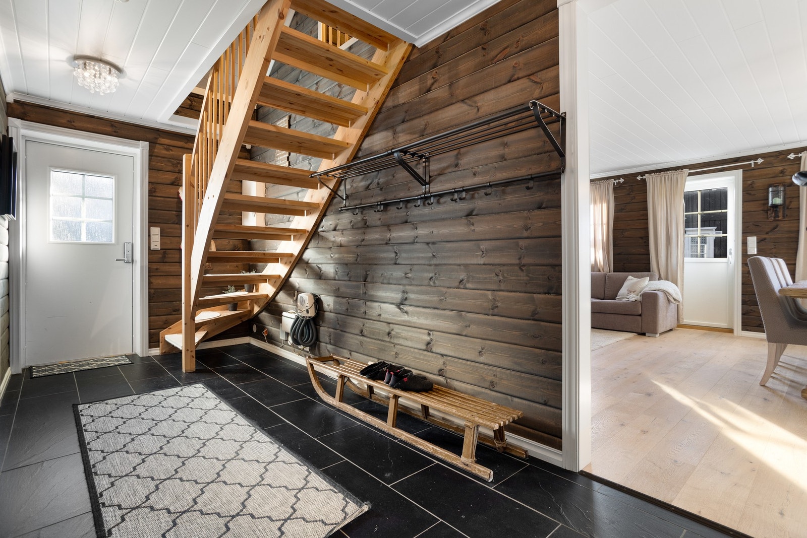 Romslig entré med flislagt gulv. Her er det god plass til oppbevaring av tøy på knaggrekke Galleribilde