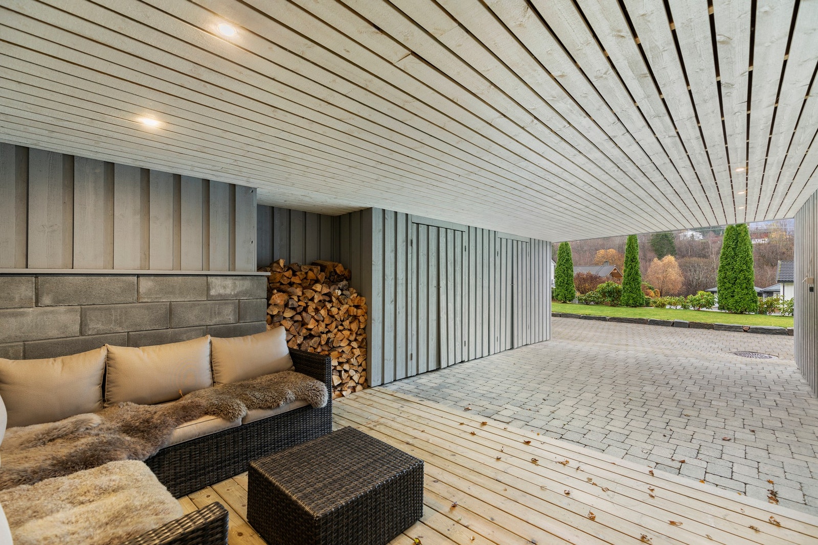 Tilbygget carport like utenfor inngangsdøren. Her er det tillaget terrasse/uteplass og praktisk sportsbod på 6 kvm. Galleribilde