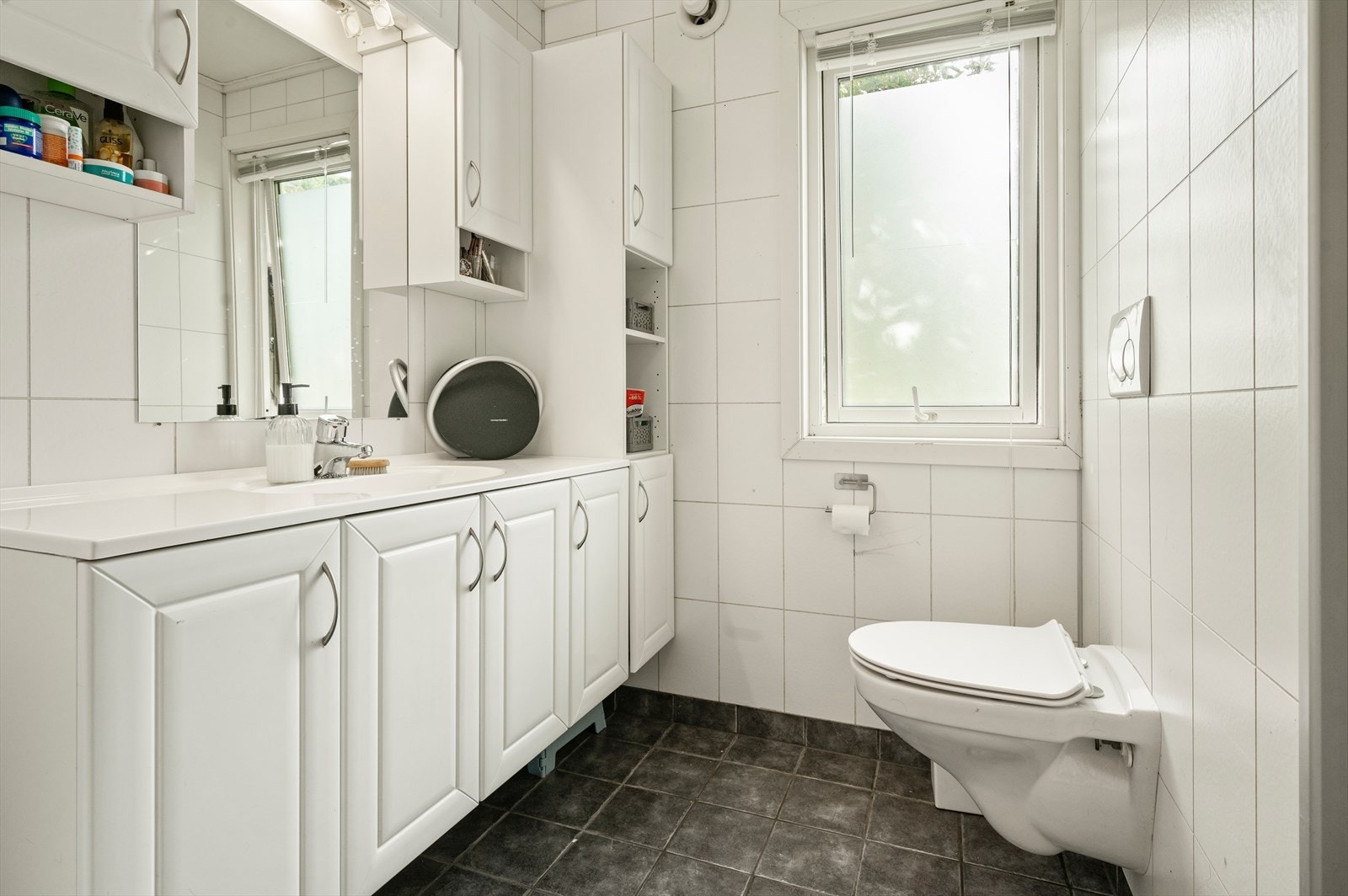 Flislagt bad med varmekabler, vegghengt wc og stor baderomsinnredning med mye skapplass. Galleribilde