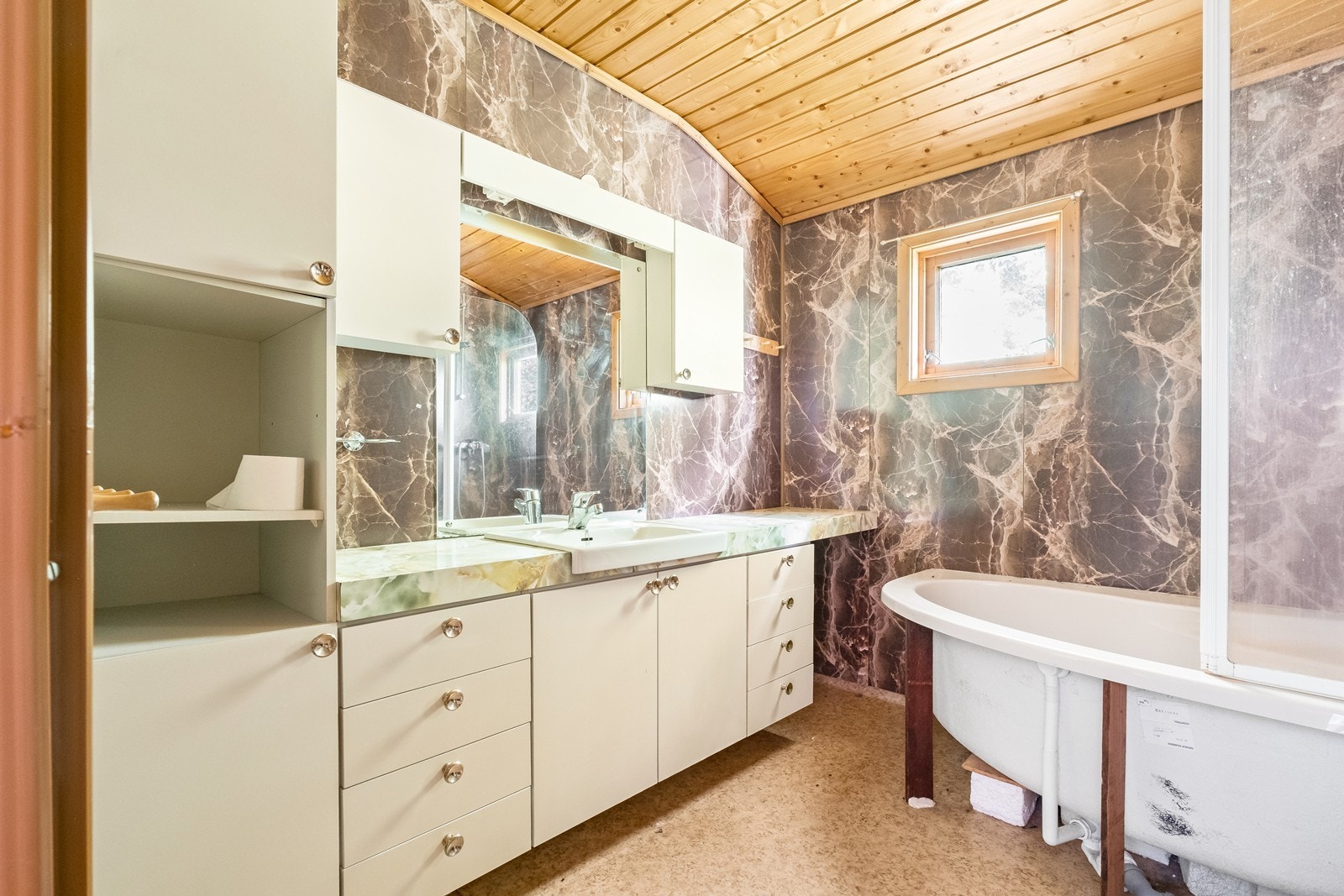 Bad på loft, med badekar og stor, eldre baderomsinnredning. Galleribilde