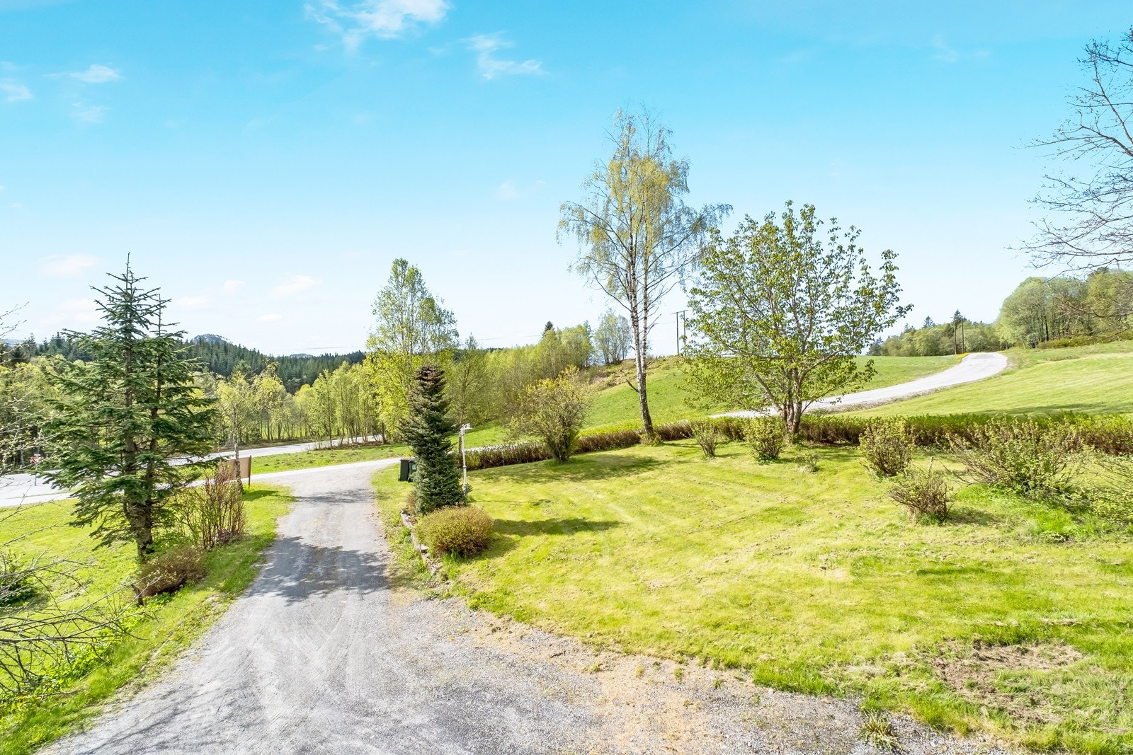 Gruset innkjørsel og opparbeidet hage. Galleribilde