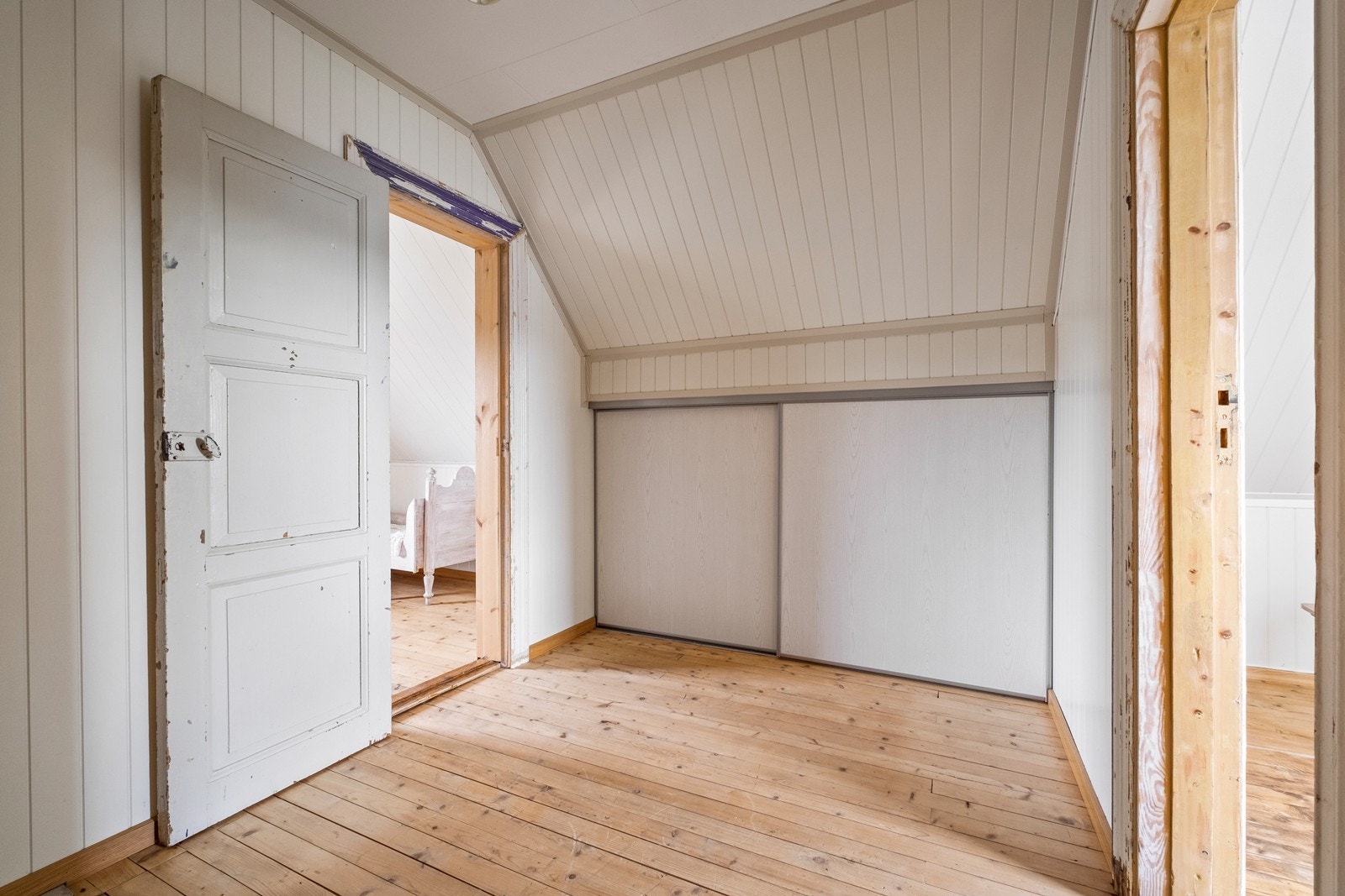 I gang mellom soverommene på loft har man lagringsplass bak skyvedører Galleribilde