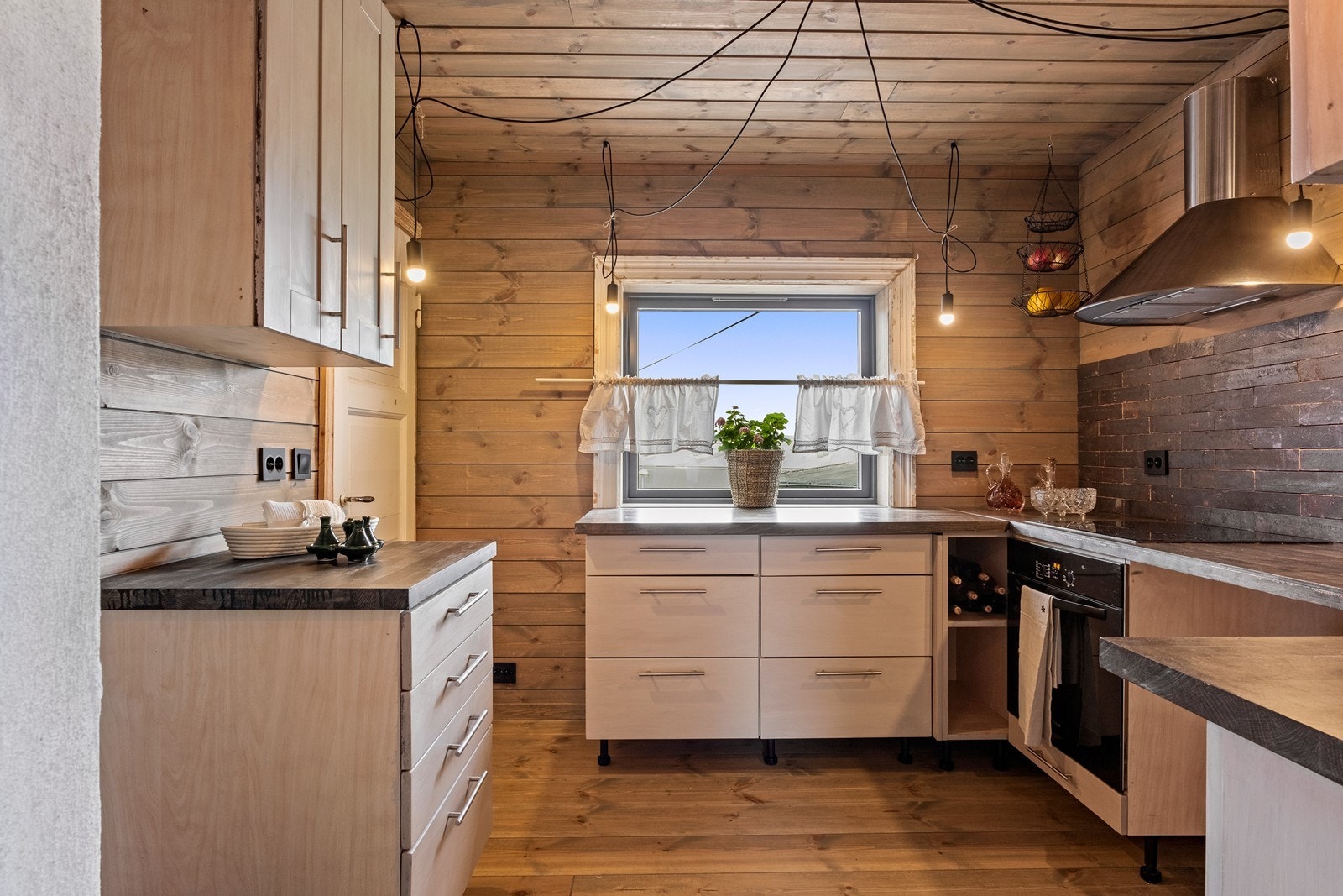 Alle vegger er utnyttet til benk- og benkeskap, og vinduet slipper inn dagslys Galleribilde