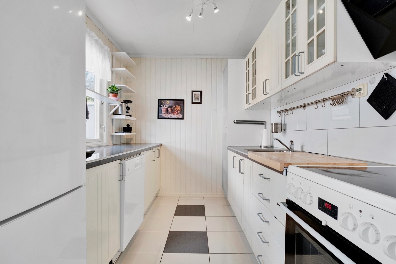 Lyst og tidløst kjøkken med rikt med både benke- og skapplass. Galleribilde